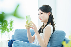 自宅でスマホを触る女性