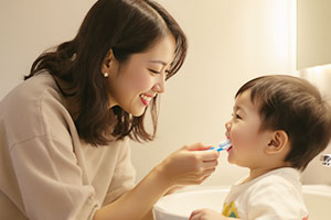 子どもに仕上げ磨きをしている様子