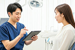 歯科医師に説明を受ける女性