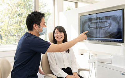 レントゲン写真を指差す歯科医師